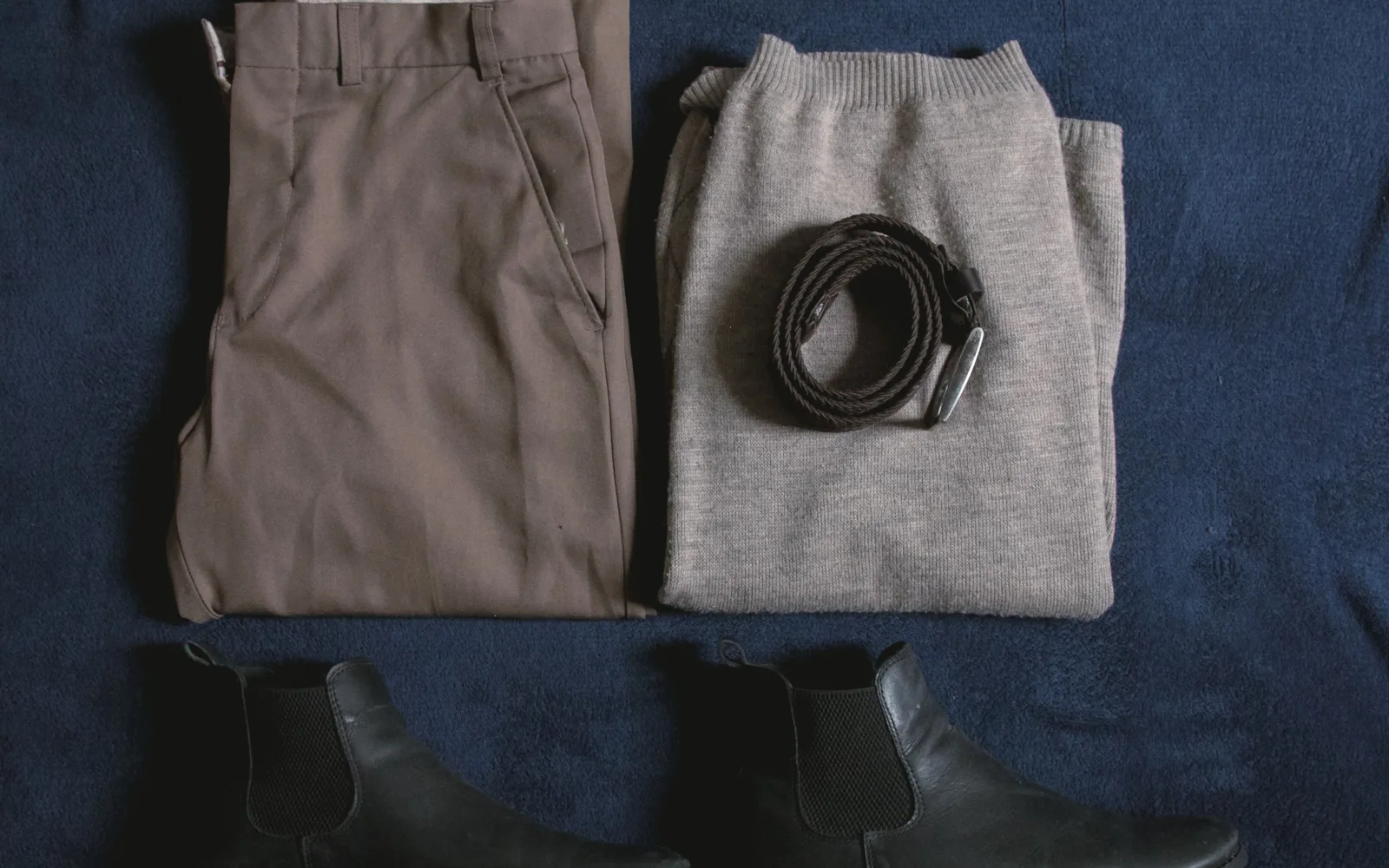 Pantalon, pull en maille, ceinture et bottines posés à plat